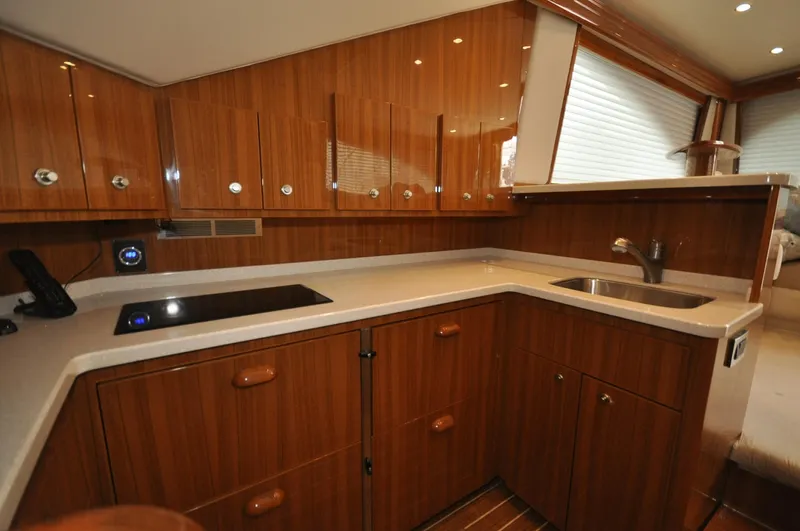  Yacht Photos Pics Luxurious kitchen interior of 2019 Viking 44 Convertible yacht with wood cabinetry and modern appliances.