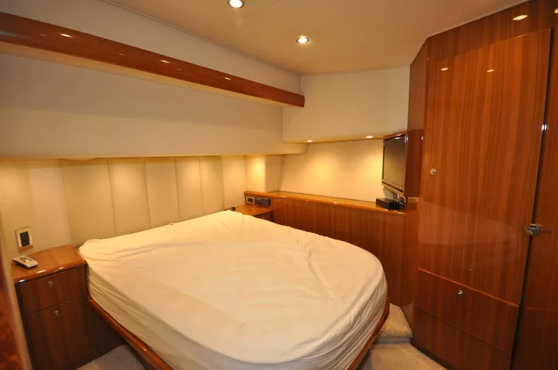  Yacht Photos Pics Luxurious bedroom interior of 2019 Viking 44 Convertible yacht with wood finishes.