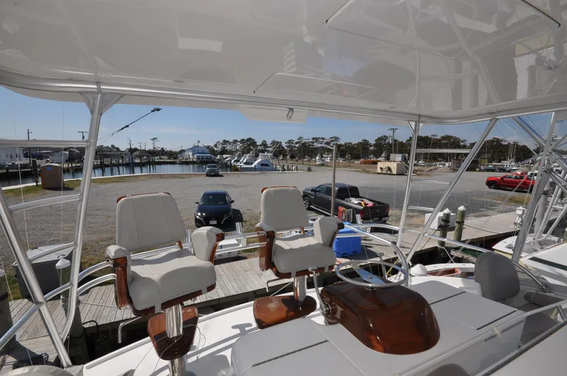  Yacht Photos Pics 2019 Viking 44 Convertible yacht with helm chairs, docked at a marina.