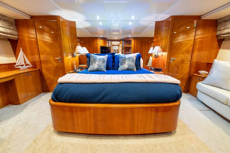  Yacht Photos Pics Luxurious master bedroom on a 1999 Azimut 100 Jumbo yacht with elegant wooden finishes.
