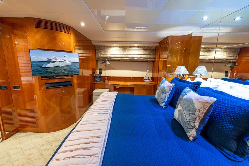  Yacht Photos Pics Luxurious bedroom on 1999 Azimut 100 Jumbo yacht with blue bedding and wooden decor.