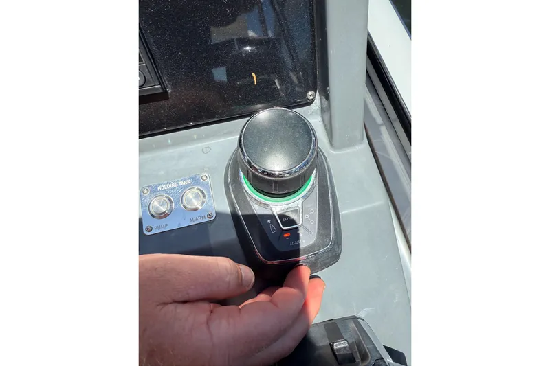  Yacht Photos Pics Hand operating joystick control on 2023 Schaefer 303 Sport boat dashboard.