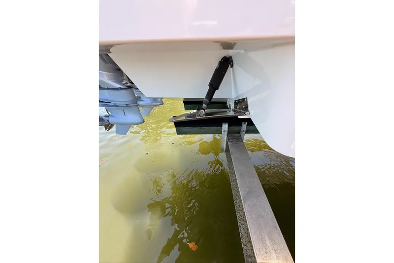  Yacht Photos Pics 2023 Schaefer 303 Sport boat detail, showing trim tab and outboard motor in water.