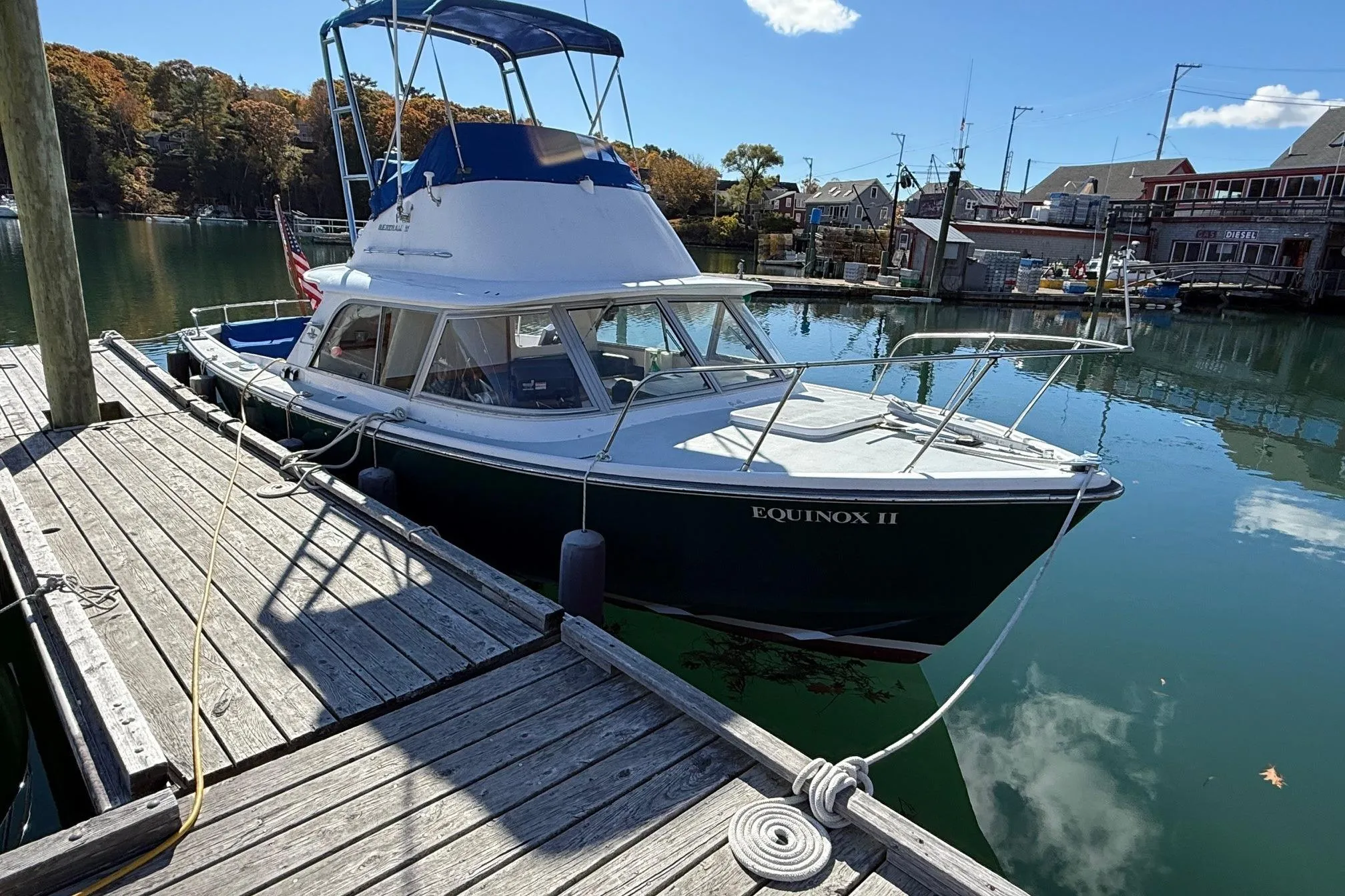 1963 Bertram 31 Flybridge Cruiser docked, named Equinox II, in a serene marina setting.
