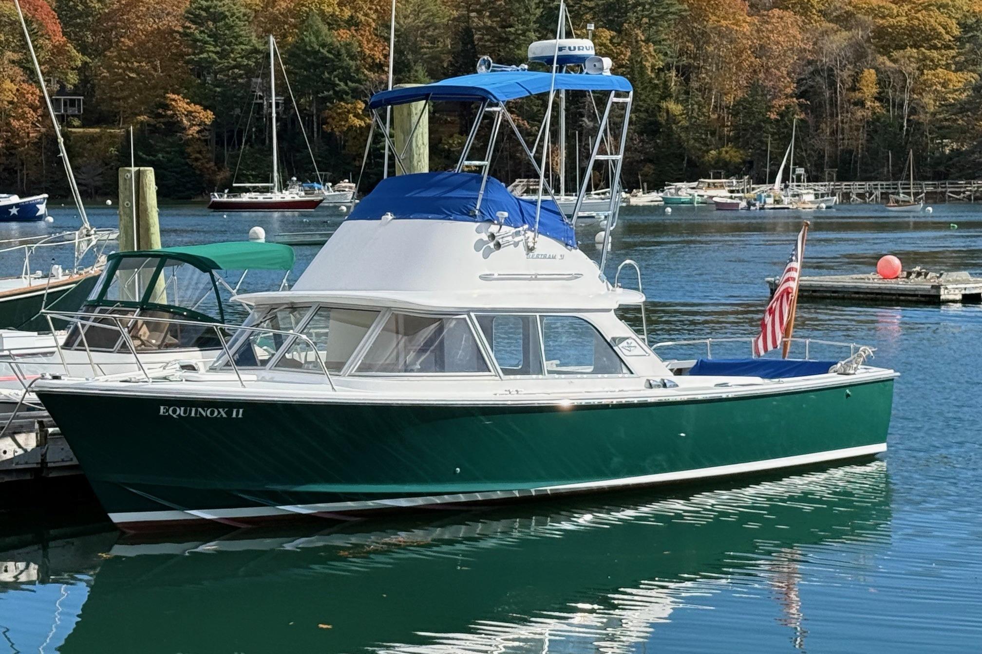 1963 Bertram 31 Flybridge Cruiser docked in a scenic marina setting.