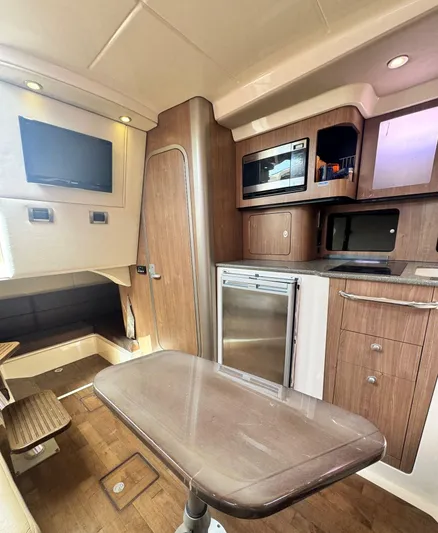  Yacht Photos Pics 2012 Boston Whaler 345 Conquest cabin interior with kitchenette and seating area.