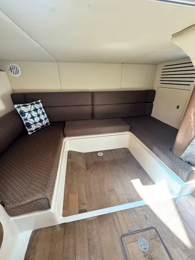  Yacht Photos Pics 2012 Boston Whaler 345 Conquest cabin interior with brown seating and wooden flooring.