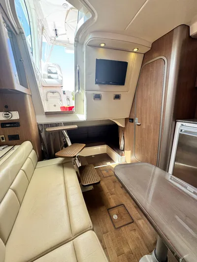  Yacht Photos Pics 2012 Boston Whaler 345 Conquest cabin interior with seating, table, and TV.