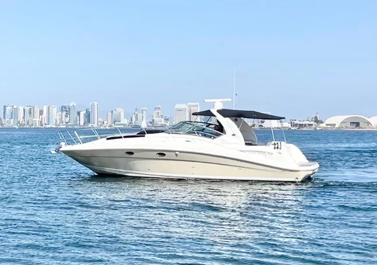  Yacht Photos Pics 2005 Sea Ray 390 Sundancer cruising on water with city skyline in background.