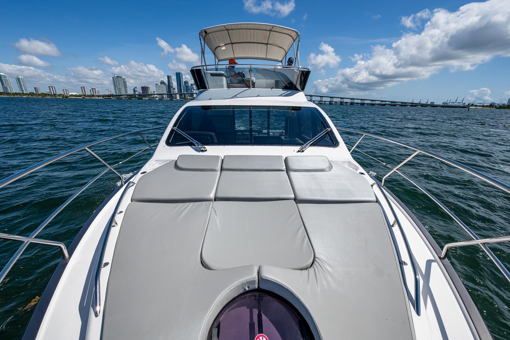 2023 Schaefer 450 yacht cruising on open water with city skyline in background.