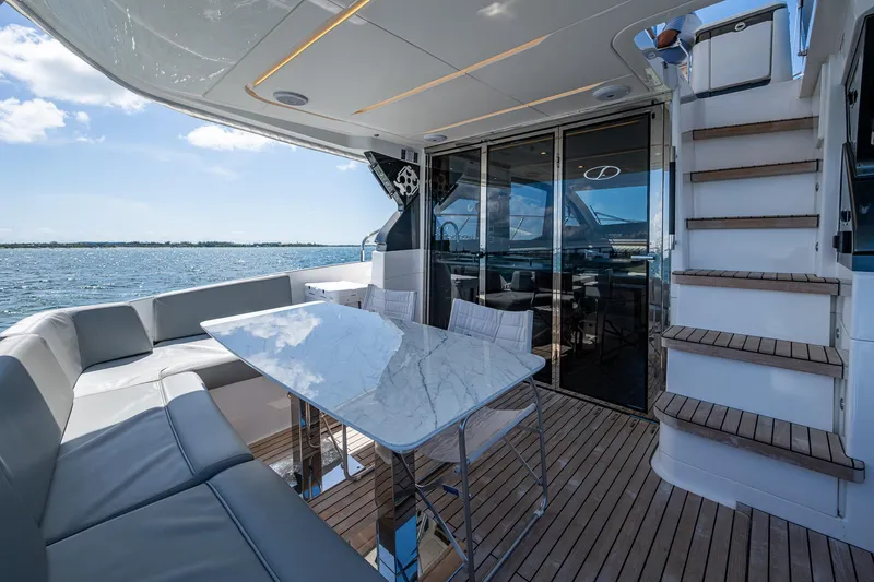 Suntastic Yacht Photos Pics Luxurious 2023 Schaefer 450 yacht deck with seating, table, and ocean view.