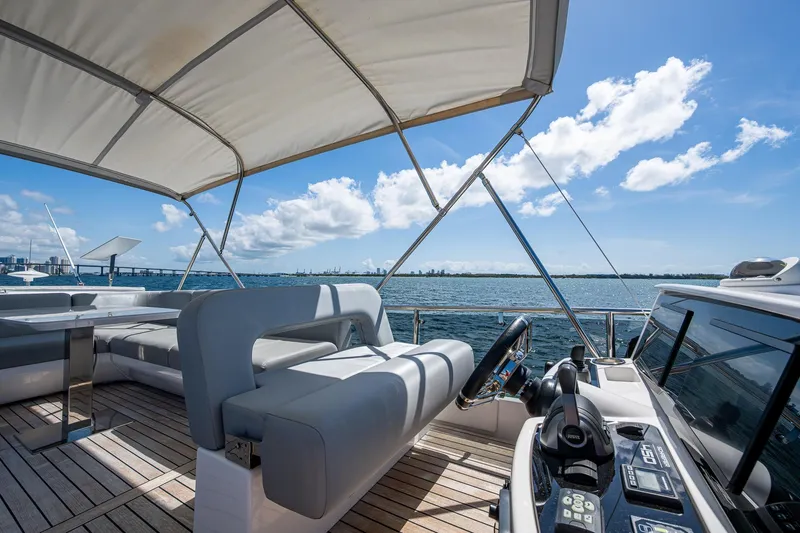 Suntastic Yacht Photos Pics Luxury Schaefer 450 yacht deck with seating, helm, and ocean view under a sunny sky.