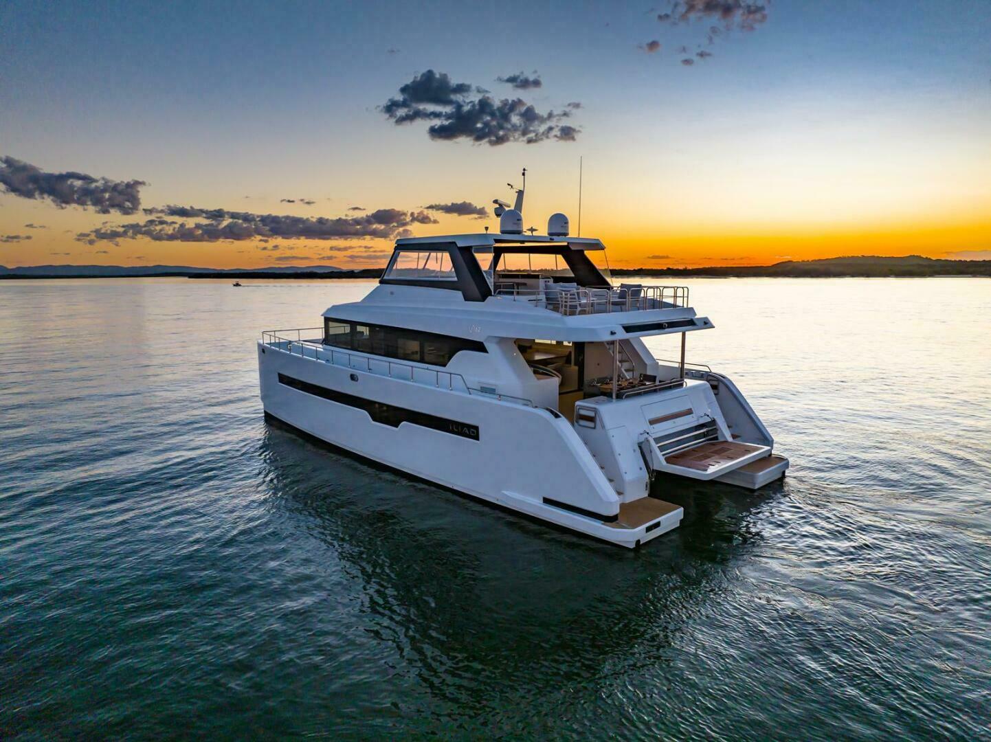 Luxurious 2026 ILIAD 62 yacht cruising at sunset on calm waters.