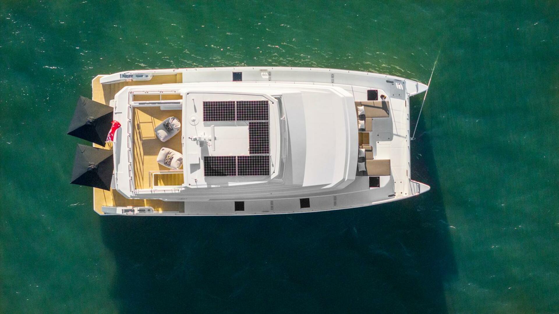 Aerial view of 2026 ILIAD 62 yacht with solar panels on turquoise water.