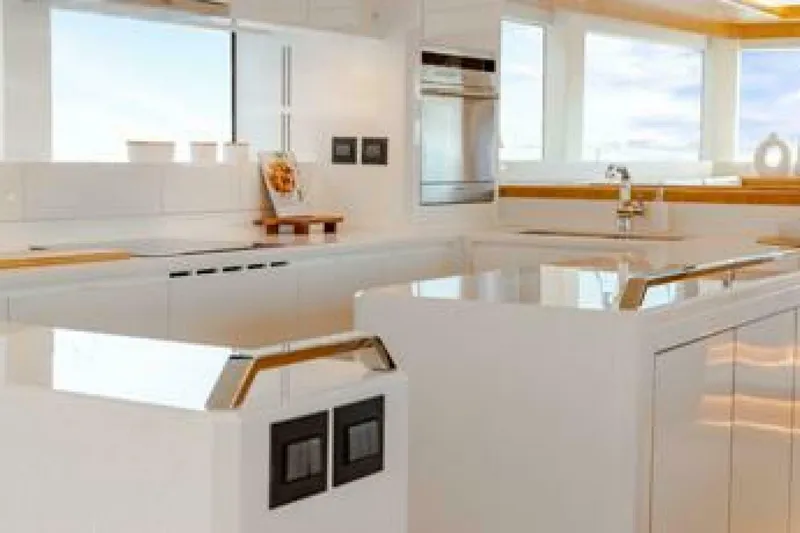 62 Iliad 2026 Yacht Photos Pics Modern yacht kitchen interior with sleek white design, featuring stainless steel appliances and ample natural light.