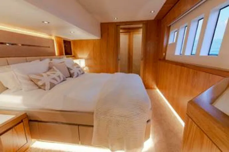 62 Iliad 2026 Yacht Photos Pics Luxurious bedroom interior on 2026 ILIAD 62 yacht, featuring elegant wood finishes and modern design.