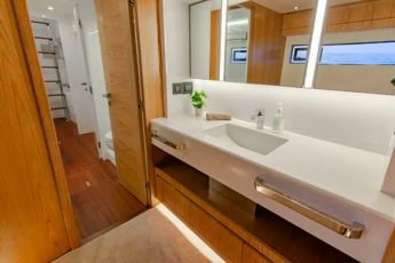 62 Iliad 2026 Yacht Photos Pics Luxurious bathroom on ILIAD 62 yacht, featuring modern sink, wooden accents, and elegant lighting.
