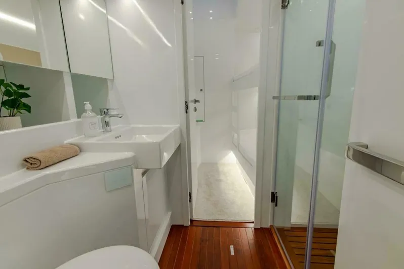 62 Iliad 2026 Yacht Photos Pics Modern bathroom on ILIAD 62 yacht, featuring sleek design, wooden flooring, and glass shower.