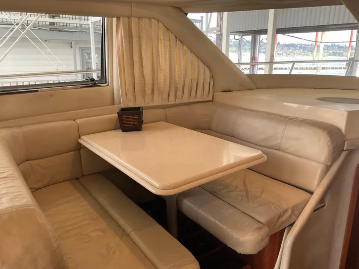  Yacht Photos Pics 1999 Sea Ray 560 Sedan Bridge interior dining area with beige seating and table.