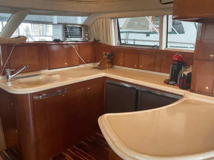 Yacht Photos Pics Luxurious kitchen interior of 1999 Sea Ray 560 Sedan Bridge yacht with wooden cabinetry.