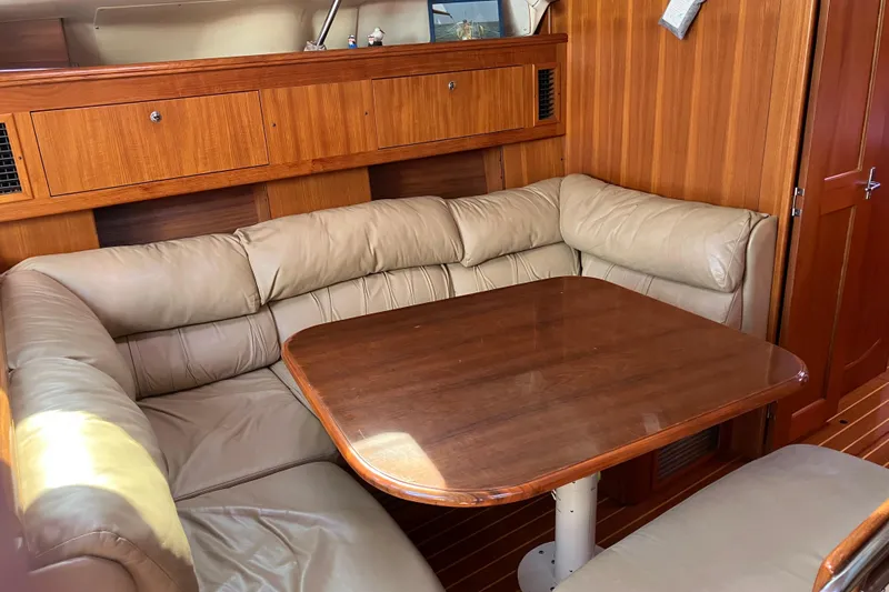 Willoughby Yacht Photos Pics Cozy interior of 2002 Hunter 460 yacht with wooden table and leather seating.