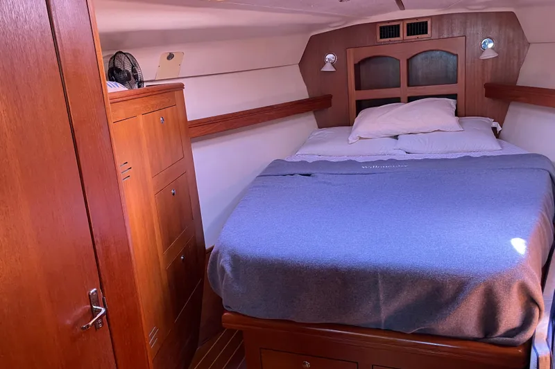 Willoughby Yacht Photos Pics Cozy cabin interior of 2002 Hunter 460 sailboat with wooden furnishings and comfortable bedding.