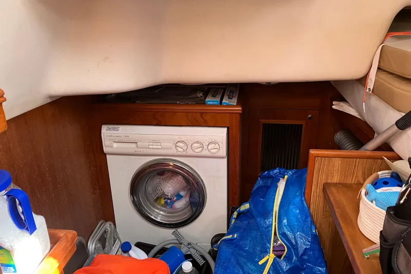 Willoughby Yacht Photos Pics Laundry area inside a 2002 Hunter 460 yacht with washing machine and storage items.