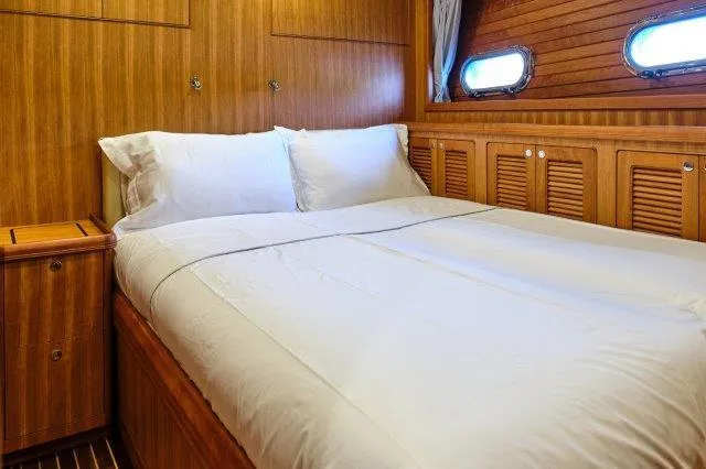  Yacht Photos Pics Luxurious cabin interior of 2026 Selene 72 Explorer yacht with cozy bed and wooden paneling.