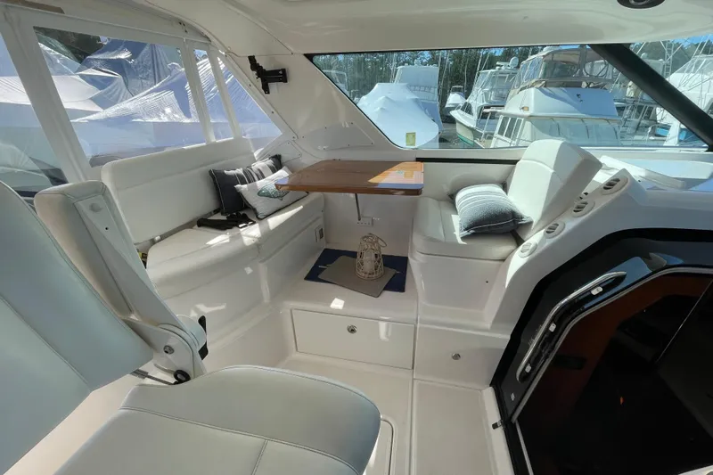 Radio Flyer Yacht Photos Pics Interior of 2005 Tiara Yachts 4400 Sovran, featuring white seating and a wooden table.