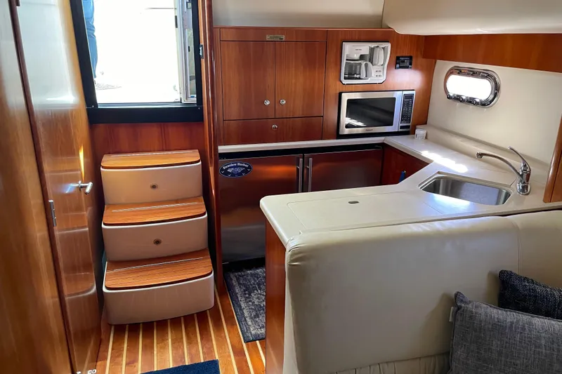 Radio Flyer Yacht Photos Pics 2005 Tiara Yachts 4400 Sovran interior with kitchen, stairs, and wooden cabinetry.