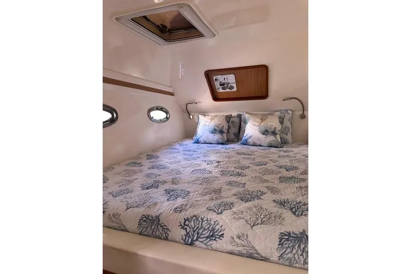 Sea Angel Yacht Photos Pics Cozy cabin interior of 2007 Africat Marine 420 with nautical-themed bedding.