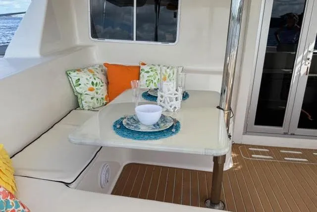 Sea Angel Yacht Photos Pics Cozy dining area on 2007 Africat Marine 420 yacht with colorful cushions and tableware.