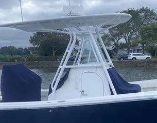  Yacht Photos Pics 2013 Regulator 26 FS boat with T-top, docked by a scenic waterfront.