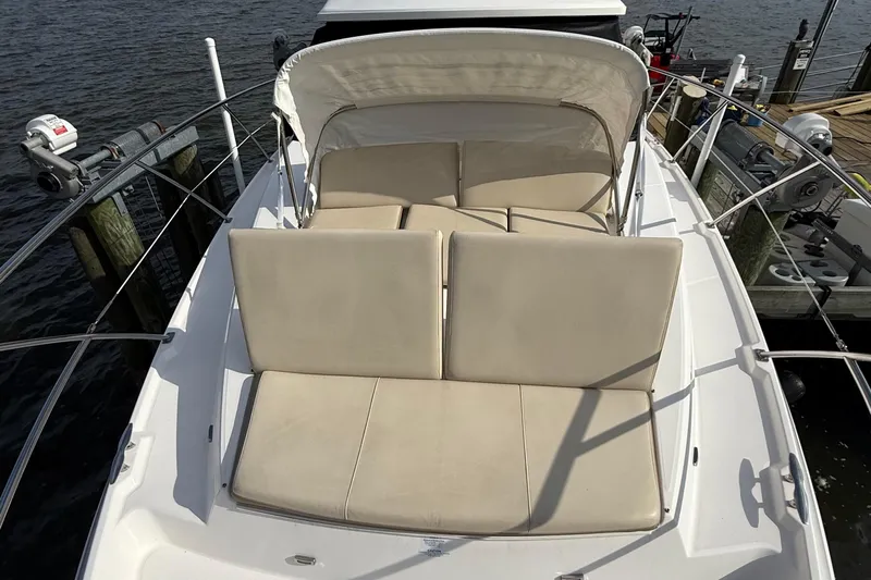 Tomtanic Yacht Photos Pics 2019 Regal 42 Fly yacht with beige cushioned seating on deck, docked by the water.