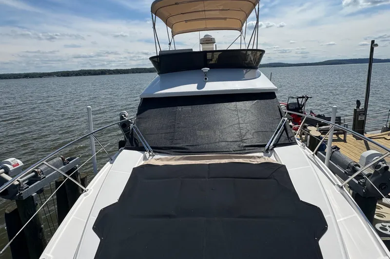 Tomtanic Yacht Photos Pics 2019 Regal 42 Fly yacht docked by the water, featuring a spacious deck and canopy.