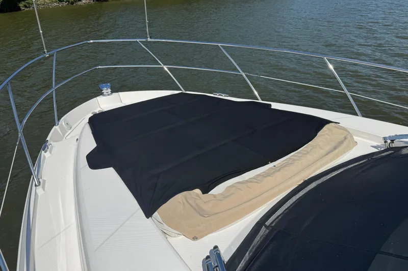 Tomtanic Yacht Photos Pics 2019 Regal 42 Fly yacht bow with sunpad cover on calm water.