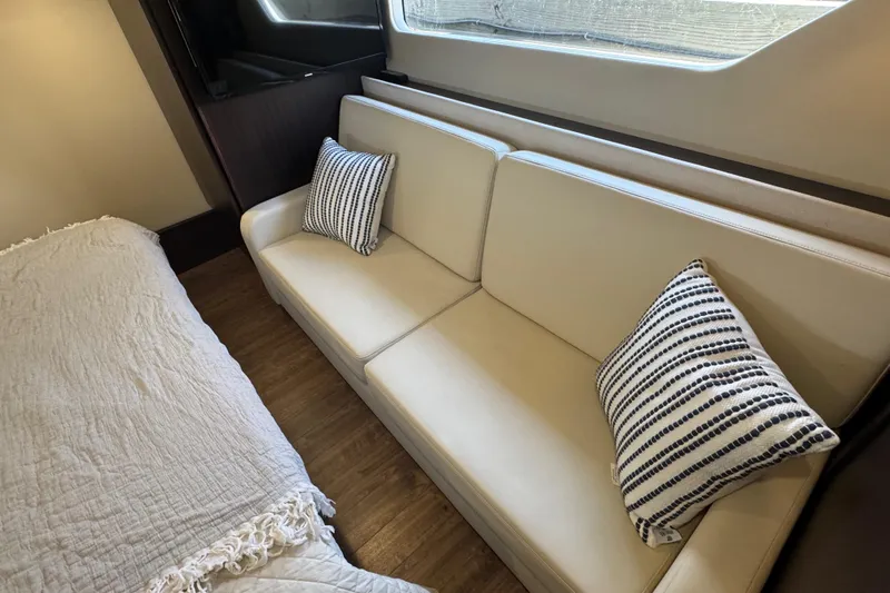 Tomtanic Yacht Photos Pics Luxurious interior of 2019 Regal 42 Fly yacht with beige sofa and striped pillows.
