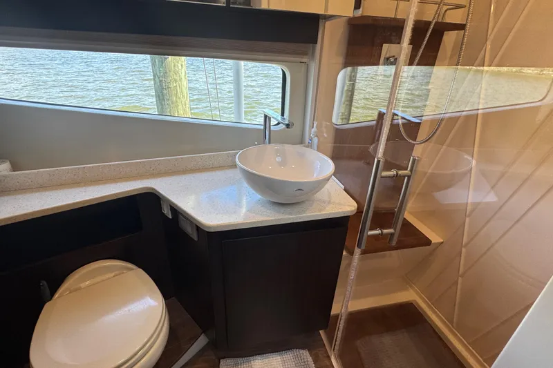 Tomtanic Yacht Photos Pics Luxurious bathroom in 2019 Regal 42 Fly yacht with modern fixtures and water view.