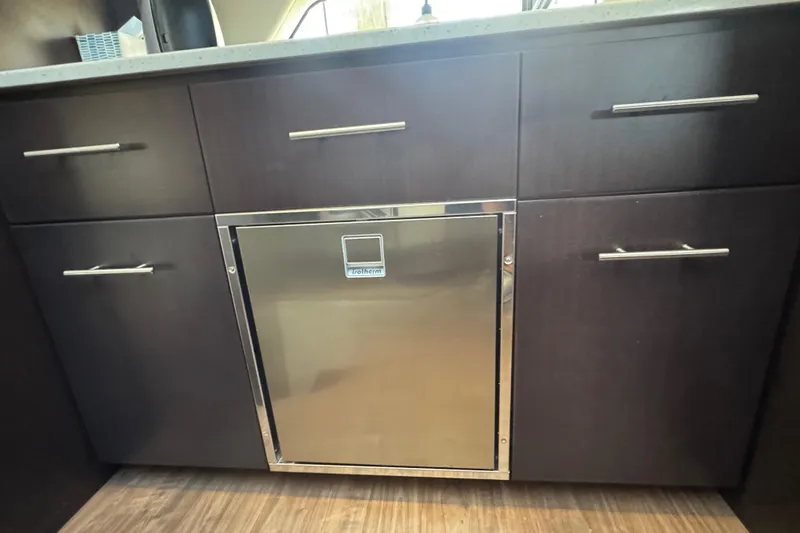 Tomtanic Yacht Photos Pics Dark wood cabinetry with stainless steel fridge in 2019 Regal 42 Fly yacht interior.