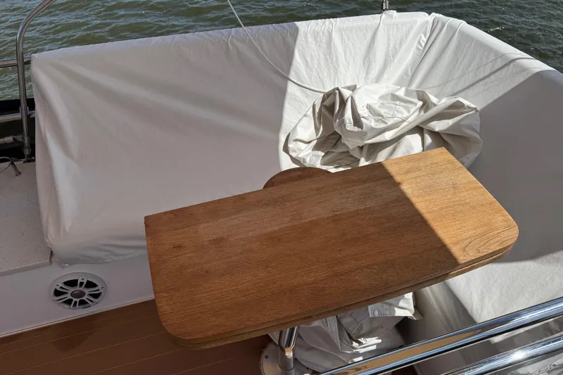 Tomtanic Yacht Photos Pics Wooden table on a 2019 Regal 42 Fly yacht with white seating and water view.