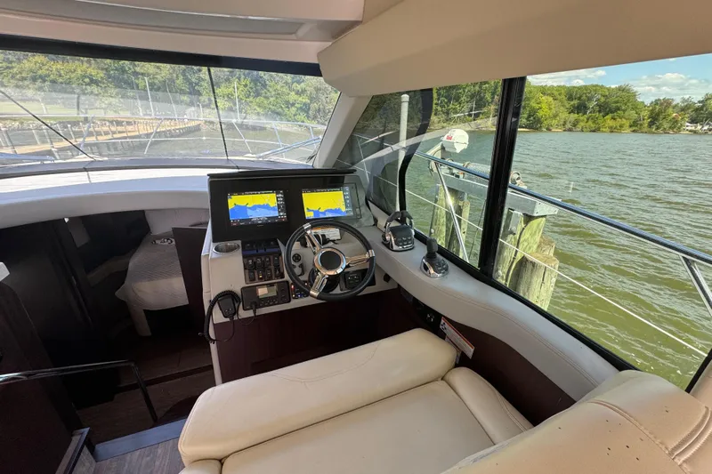 Tomtanic Yacht Photos Pics Interior view of 2019 Regal 42 Fly yacht cockpit with navigation screens and steering wheel.