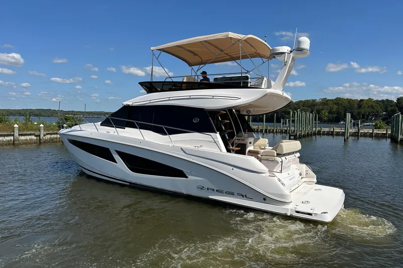Tomtanic Yacht Photos Pics 2019 Regal 42 Fly yacht cruising on a sunny day near a marina.