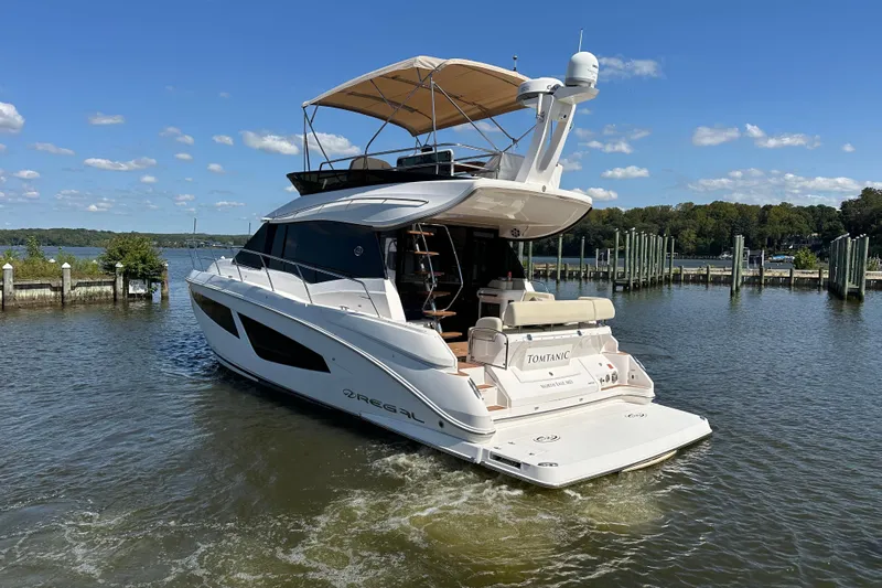 Tomtanic Yacht Photos Pics 2019 Regal 42 Fly yacht on calm water, sunny day, dock in background.