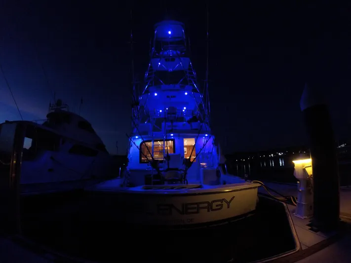  Yacht Photos Pics 2001 Hatteras 60 Convertible yacht illuminated with blue lights at night.