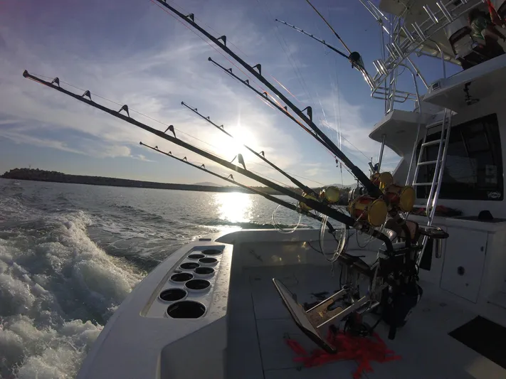  Yacht Photos Pics Fishing rods on a 2001 Hatteras 60 Convertible yacht at sea during sunset.