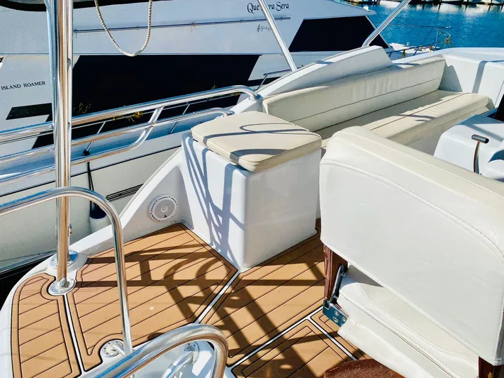  Yacht Photos Pics Luxury deck of 2001 Hatteras 60 Convertible yacht with white seating and wooden flooring.