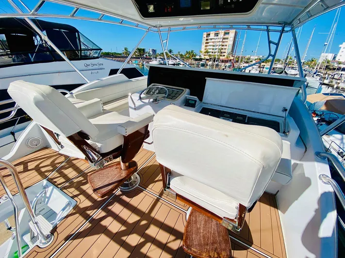  Yacht Photos Pics 2001 Hatteras 60 Convertible yacht helm with white seats and marina view.