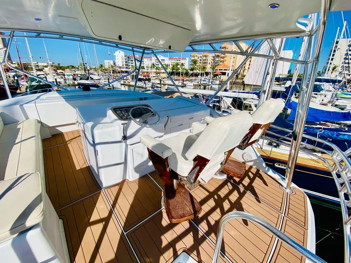  Yacht Photos Pics Helm of 2001 Hatteras 60 Convertible yacht with luxurious seating and marina view.