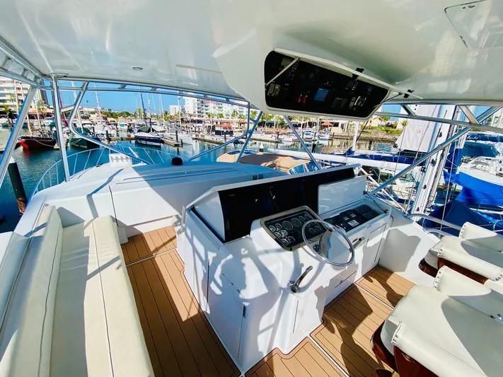  Yacht Photos Pics Flybridge of 2001 Hatteras 60 Convertible yacht with helm station and marina view.