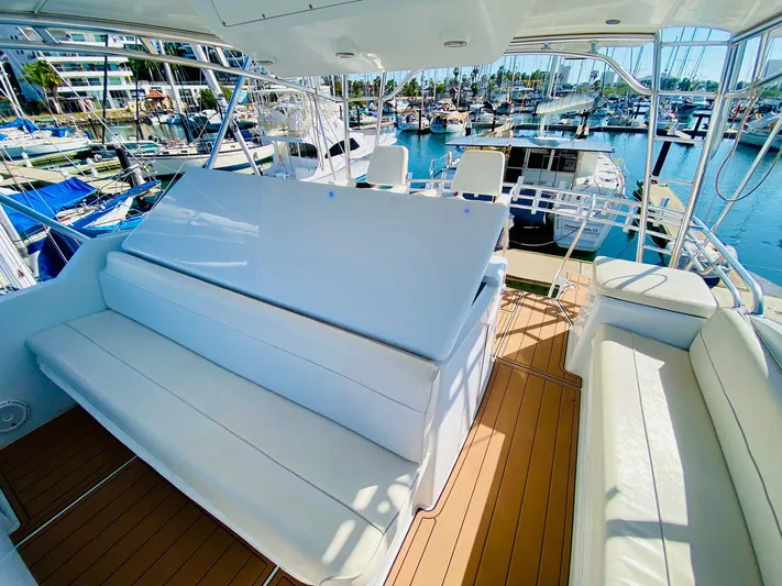  Yacht Photos Pics 2001 Hatteras 60 Convertible yacht interior with white seating and marina view.